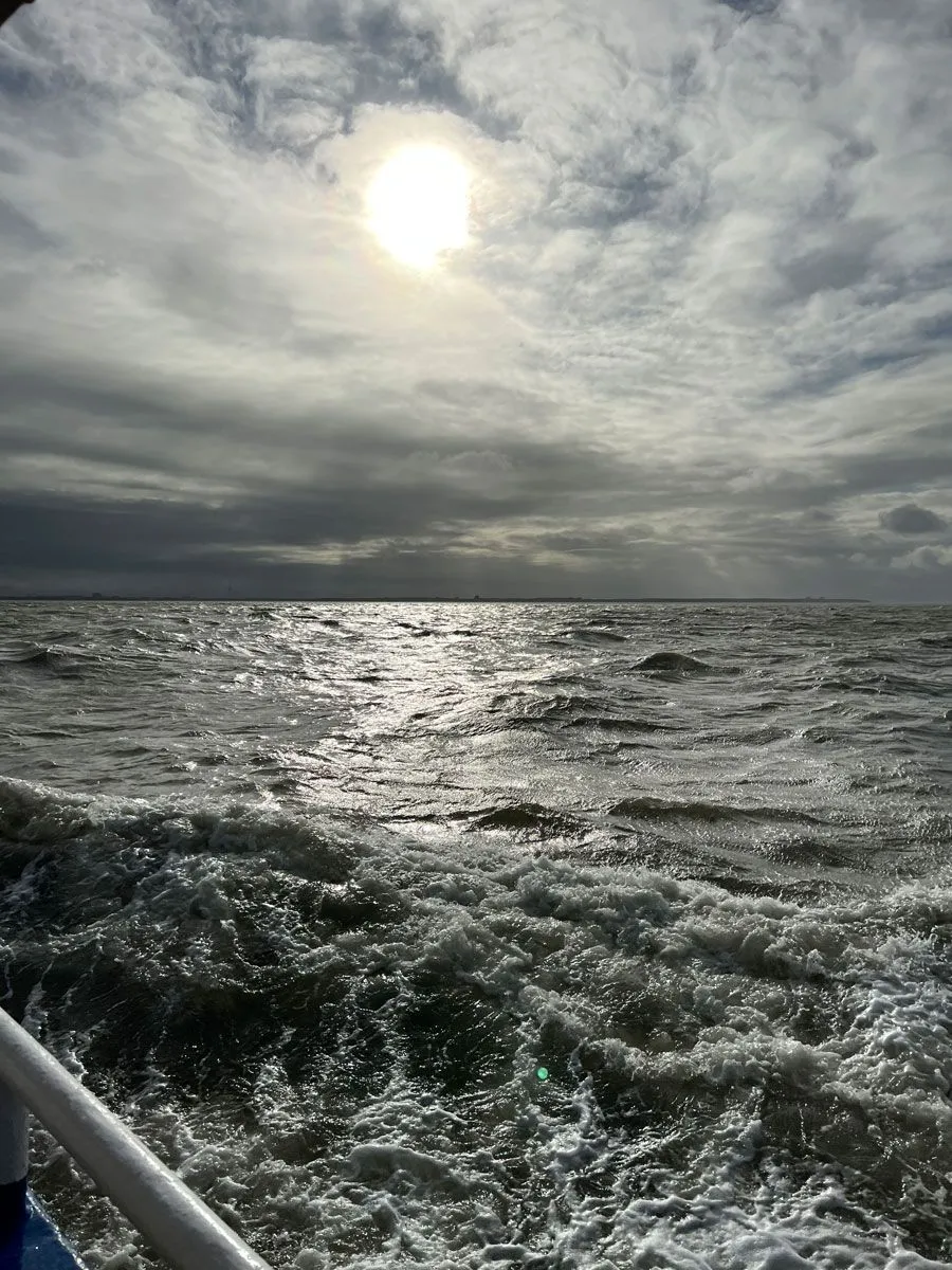 Dunkles Meerwasser mit ein wenig Sonne am Himmel