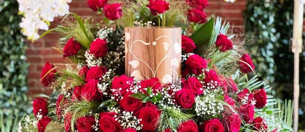 Zylinderförmige Holzurne mit Blumengesteck, rote Rosen