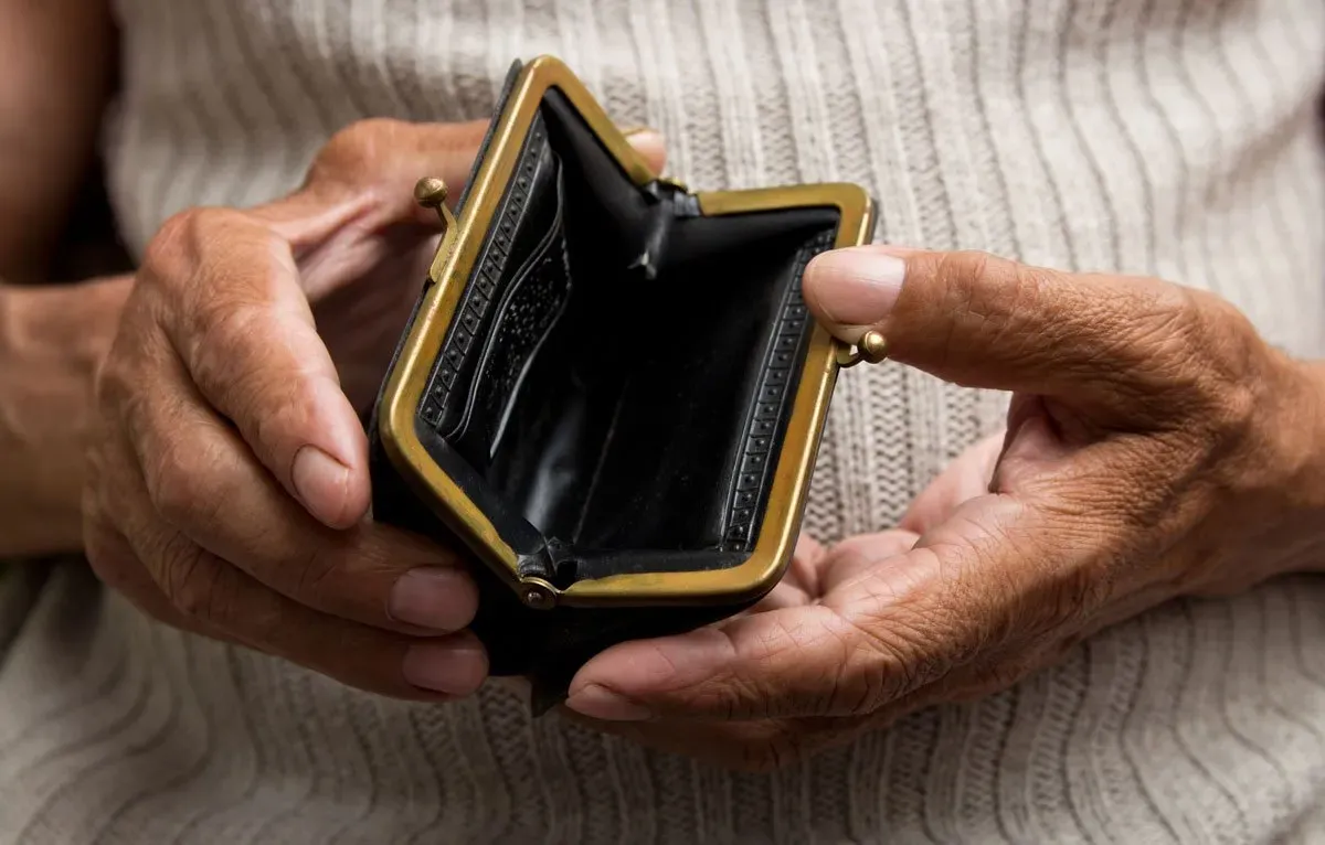 Old woman holds empty purse in her hands Funeral parlour LESCH Hannover